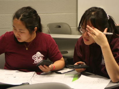 Two partners sit side by side, taking a Science Olympiad test together.